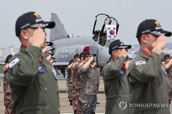 F-4 팬텀 퇴역식 (수원=연합뉴스) 7일 경기 수원시 공군 10전투비행단에서 열린 F-4 팬텀(Phantom) 퇴역식에서 조종사들을 비롯한 장병들이 국기에 경례하고 있다. 2024.6.7 [사진공동취재단] photo@yna.co.kr