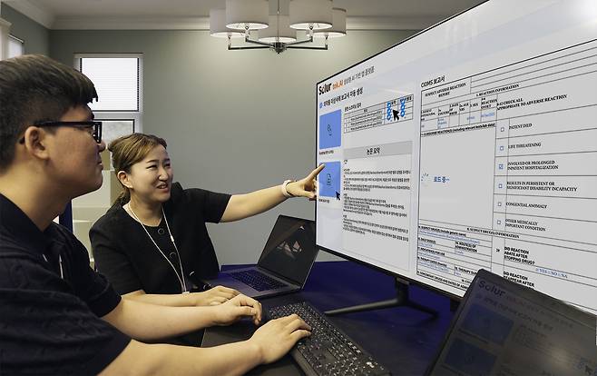 SK C&C 구성원들이 기업용 AI 설루션 '솔루어(Solur)'를 활용한 '생성형 AI 의약품 이상사례 보고서' 데모 버전을 시연하고 있는 모습(SK C&C 제공)