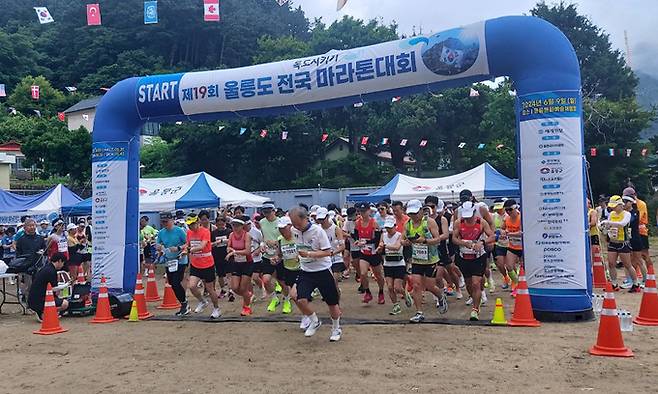 제19회 독도지키기 울릉도 전국 마라톤 대회에 700여명의 전국 각지 건각들이 출발신호에 맞춰 운동장을 빠져 나가고 있다.