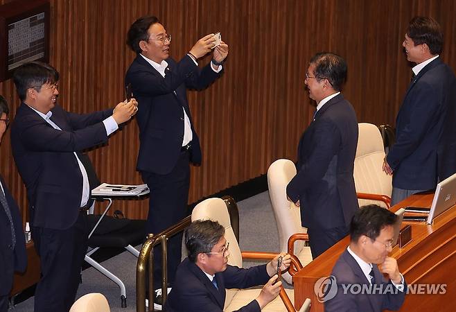 여당은 밖에서 시위, 야당은 한편에서 기념촬영 (서울=연합뉴스) 김주성 기자 = 5일 오후 서울 여의도 국회에서 열린 본회의에서 국회의장 투표가 진행되는 사이 민주당 부승찬, 손명수 의원 등이 투표를 마치고 기념촬영을 하고 있다. 이날 국민의힘 의원들은 여야 합의 없는 야당의 본회의 강행을 문제삼으며 불참했다. 2024.6.5 utzza@yna.co.kr