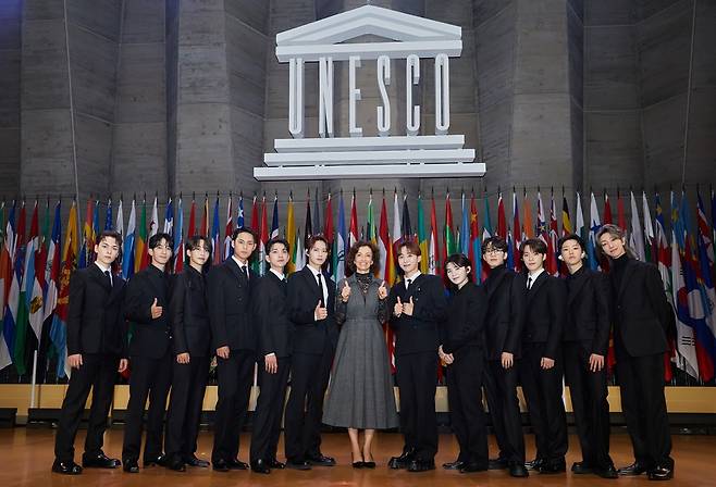 The bandmates of K-pop boy band Seventeen pose with Director General of UNESCO Audrey Azoulay (center) during the 13th UNESCO Youth Forum held at the UNESCO headquarters in Paris in November 2023. (Pledis Entertainment)