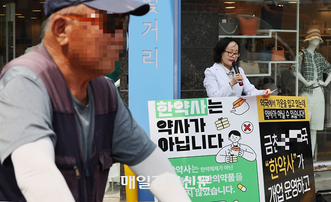 11일 금천구내 한약사가 약국 개설 예정으로 논란인 가운데 이를 저지하기 위한 지역 약사회 차원에서의 대응을 하고있다.
서울 24개 분회가 지난  10일부터 금천구 내 한약사 개설 약국에 대응하기 위해 약국 인근에서 1인 릴레이 시위를 이어간다.
해당 약국은 한약사가 금천구내 병원이 모여있고 시장 인근 유동인구가 많은 한 지역에 개설될 예정이었다.
약국은 개설 전임에도 외부 간판에 일반의약품, 병의원처방조제, 동물의약품, 건기식, 한약상담 등 약사가 개설한 약국과 동일한 기능을 홍보하고 있어 논란이 일었다.
현재 병의원처방조제 문구는 지워졌지만 일반의약품의 난매로 유명한 종로지역을 언급하며 종로까지 갈 필요가 없다면서 홍보하고 있는 상황이었다.2024.06.11[이충우기자]