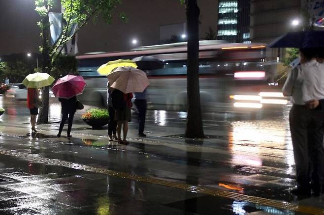 여름 밤 내리는 비와 집으로 가는 사람들과 우산과 질주하는 버스는 말로 덮을 수 없는 진실한 무의미로 공간을 채운다. (서울 광화문, 2013) ⓒ허영한