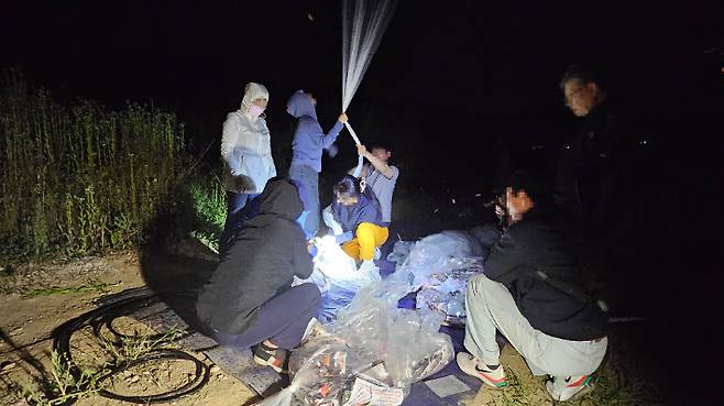 탈북민 단체 겨레얼통일연대 회원들이 지난 7일 밤 강화도에서 대북 전단을 살포하는 모습. 겨레얼통일연대 측 제공