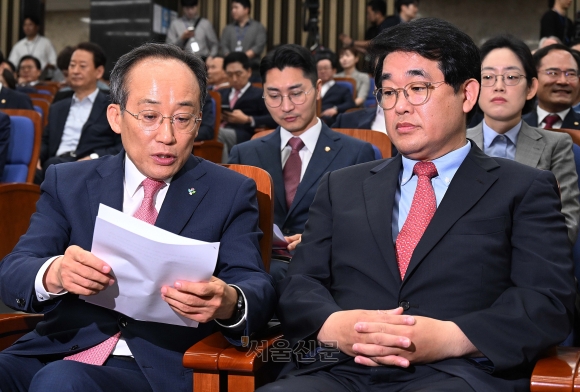 추경호(앞줄 왼쪽) 국민의힘 원내대표와 배준영(오른쪽) 원내수석부대표가 11일 국회에서 열린 의원총회에서 함께 자료를 들여다보고 있다. 국민의힘은 의원총회에서 더불어민주당의 일방적인 원 구성에 반발해 상임위원회 활동을 전면 거부하는 방안 등을 논의했다. 오장환 기자