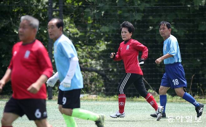 송파구70대축구단의 ‘홍일점’ 정애자 씨(오른쪽에서 두 번째)가 서울 송파여성축구장에서 친선경기를 하고 있다. 변영욱 기자 cut@donga.com