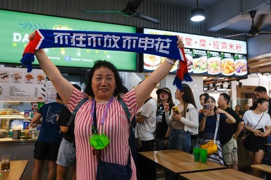 중국 축구 팬이 서니의 가게에서 기념사진을 찍는 모습. AP연합뉴스