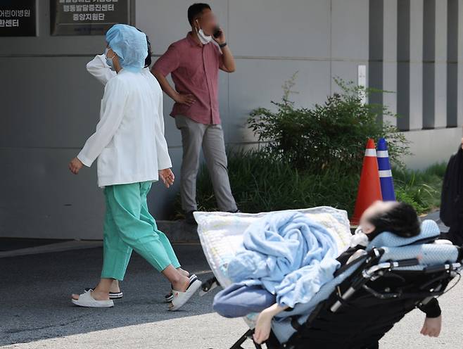 서울 종로구 서울대병원에서 한 소아환자 인근으로 의료진이 지나고 있다 .    연합뉴스