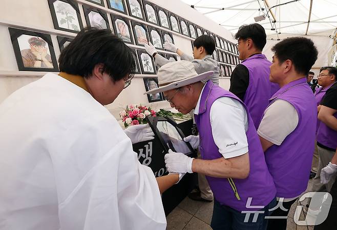 10·29 이태원 참사 희생자 유가족들이 16일 오후 서울 중구 서울광장에서 열린 희생자 합동분향소 운영 종료식에서 4대 종단 관계자들에게 영정 사진을 전달받고 있다. 2024.6.16/뉴스1 ⓒ News1 김진환 기자