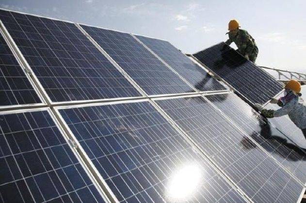 중국 신장위구르자치구 하미시의 태양광 발전소에서 근로자들이 태양광 패널을 설치하고 있다. ⓒ AP/뉴시스