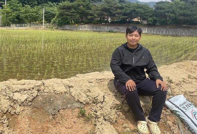 문전옥답을 배경으로 논두렁에 앉은 한태웅 씨 [연합뉴스. 재판매 및 DB 금지]