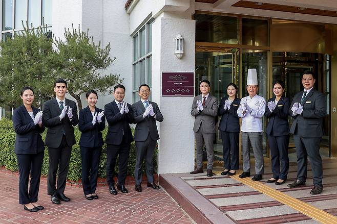 이지운 (왼쪽 6번째) 이랜드파크 대표와 권순범(왼쪽 5번째) 국내호텔 BU장 등 이랜드파크 관계자들이 켄싱턴호텔 평창 현판식에서 기념촬영하고 있다. [이랜드파크 제공]
