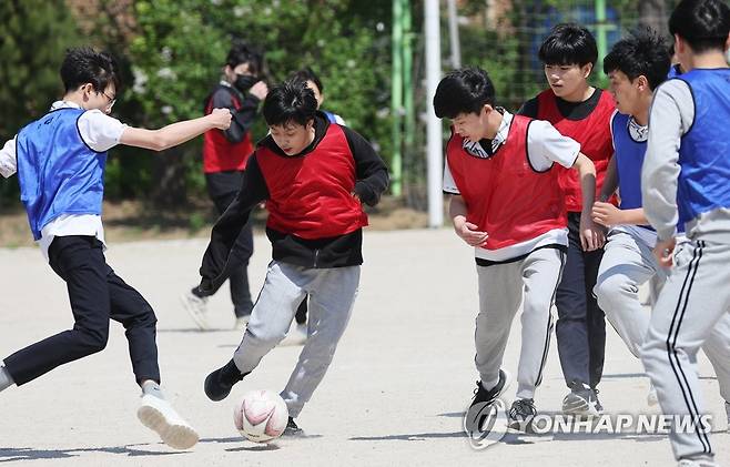 지난 2022년 5월 2일 경기도 수원의 한 중학교에서 학생들이 마스크를 벗고 축구를 하고 있다. [연합뉴스 자료사진. 재판매 및 DB 금지]
