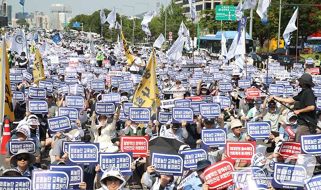 18일 서울 영등포구 여의도 환승센터 주변에서 열린 대한의사협회 전국 의사 총궐기대회에서 참석자들이 손팻말을 들고 정부의 '의대 증원' 철회를 촉구하고 있다. 2024.6.18/뉴스1 ⓒ News1 임세영 기자