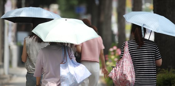 폭염이 계속된 14일 오후 대구 중구 국채보상로에서 양산을 쓴 시민들이 걸어가고 있다. 뉴스1