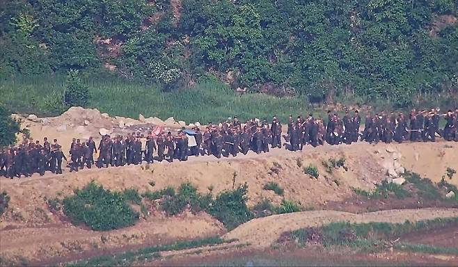 Dozens of North Korean soldiers are seen at work near the border in this photograph take by the South Korean Joint Chiefs of Staff. (JCS)