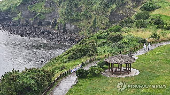 비 내리는 제주 (서귀포=연합뉴스) 박지호 기자 = 비가 내리기 시작한 17일 오전 제주 서귀포시 대정읍 송악산을 찾은 관광객이 산책하고 있다. 2024.6.17 jihopark@yna.co.kr