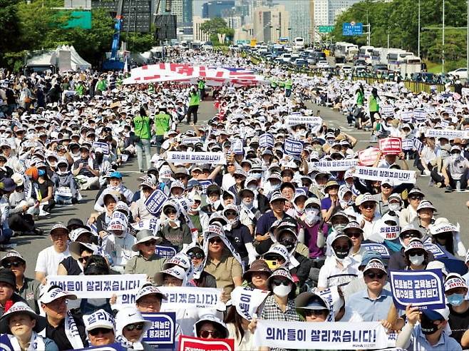 < 또다시 거리로 나선 의사들 > 18일 서울 여의도 환승센터 주변에서 열린 대한의사협회 ‘전국 의사 총궐기대회’에 참여한 의사들이 정부에 의대 증원 정책 철회를 촉구하고 있다.   임대철 기자