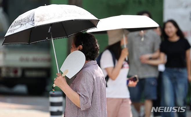 [대구=뉴시스] 이무열 기자 = 전국 곳곳에 폭염주의보가 발효된 19일 대구 중구 동성로에서 한 시민이 부채를 들고 이동하고 있다. 2024.06.19. lmy@newsis.com