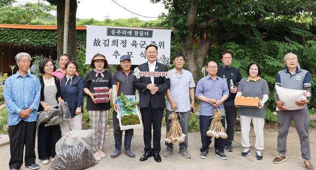 경북 칠곡군 가산면 응추리 마을주민들과 김재욱 칠곡군수가  20일 고 김희정 중위 유가족에게 보낼 농산물을 들고 기념 촬영을 하고 있다.   칠곡군 제공