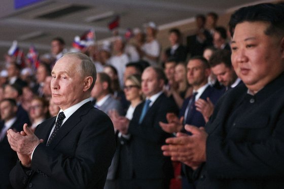 19일 평양에서 열린 공연에서 군중과 함께 박수를 치고 있는 푸틴 러시아 대통령과 김정은 북한 국무위원장. AFP=연합뉴스