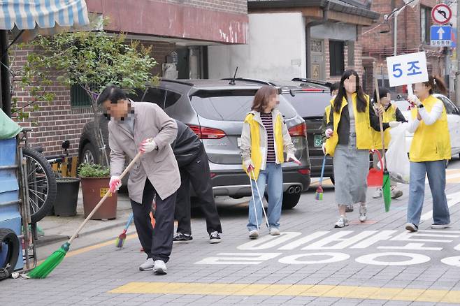 조끼 입고 도시 미관 정화 서울 A구 공무원들과 지역 단체 소속 주민들이 지난 4월 ‘주민자율 대청소’를 진행하고 있다. A구 홈페이지 캡처