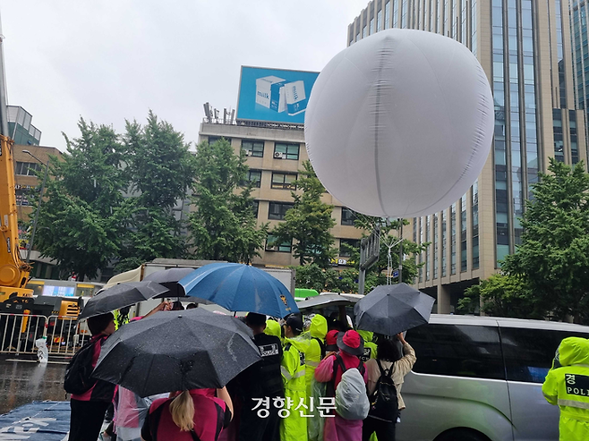 민주노총 전국학교비정규직노동조합이 지난 22일 총궐기 대회에서 헬륨 가스 풍선 사용을 놓고 경찰과 실랑이를 벌이고 있다. 강한들 기자