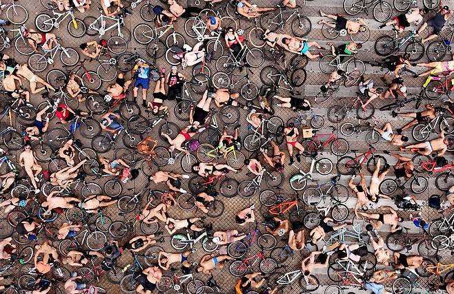 2024년 6월 22일(현지시각) 멕시코 할리스코주 과달라하라에서 열린 월드 네이키드 바이크 라이드(World Naked Bike Ride) 참가자들이 자전거와 함께 도로에 누워 시위를 하고 있다. 멕시코에서는 매년 수 천 명이 나체 자전거 타기 행사에 참가해 지나친 자동차 사용으로 지구가 망가져가는 것을 고발하고 환경보호를 호소하고 있다. /AFP 연합뉴스