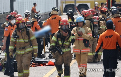 24일 경기도 화성시 서신면 소재 일차전지 제조업체 공장 화재 현장에서 소방관들과 구급대원들이 시신을 수습하고 있다.   [연합뉴스]