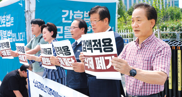 20일 서울 영등포구 여의도 국회 정문 앞에서 열린 소상공인연합회의 최저임금법 개악 항의 기자회견에서 참석자들이 구호를 외치고 있다. [연합]