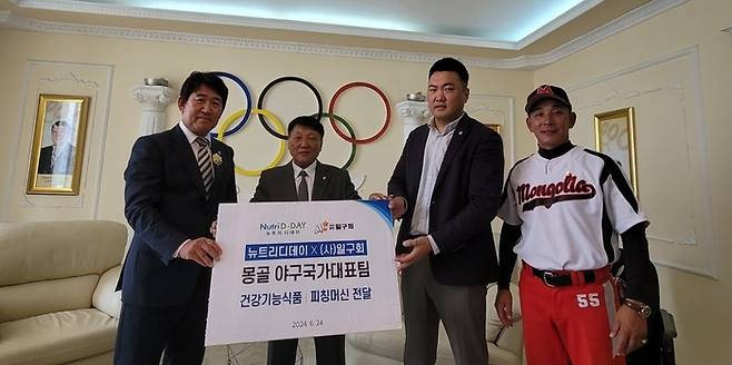 KBO 조계현 기술위원장(왼쪽)과 일구회 이경필 감사 (왼쪽에서 세 번째) 등이 몽골 야구대표팀을 찾아 피칭머신 등을 전달하고 기념촬영하고 있다. 사진 | 일구회