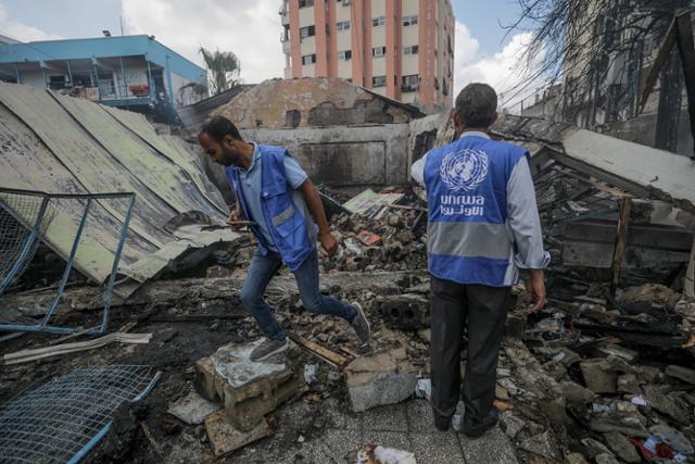 유엔 팔레스타인 난민보호기구(UNRWA) 관계자들이 지난달 14일 이스라엘군의 공격에 파괴된 가자지구 중심부 누세이라트 난민캠프 인근 유엔 학교시설 등을 살펴보고 있다. EPA 연합뉴스