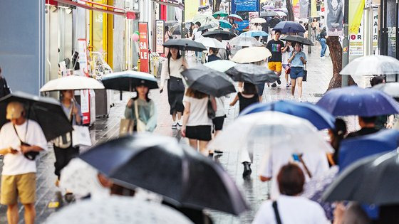 비가 내린 22일 오전 서울 명동거리에 시민들과 관광객들이 우산을 쓰고 이동하고 있다. 연합뉴스