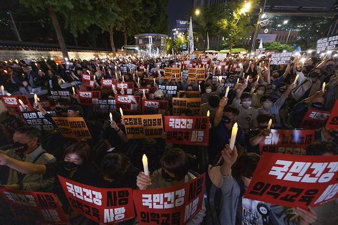 지난달 30일 오후 서울 중구 덕수궁 대한문 앞에서 대한의사협회 주최로 열린 대한민국 정부 한국 의료 사망선고 촛불집회에 참가한 의사들이 한국 의료를 향한 묵념을 하고 있다. /연합뉴스