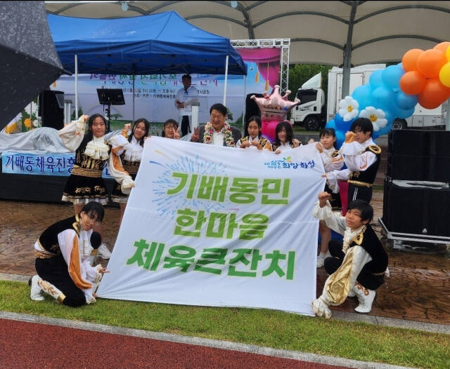 지난 22일 화성시 기배역사공원에서 열린 ‘기배동 한마음 체육큰잔치’에서 기안중학교 치어리딩 무아지경팀이 제작한 축하현수막을 들고 기념촬영을 하고 있다. 기배동 체육진흥회 제공