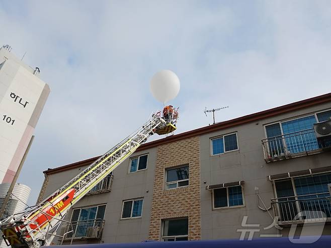 지난 9일 오전 5시 32분쯤 인천 미추홀구 학익동 한 빌라 옥상에 떨어진 오물풍선을 소방대원이 치우고 있다.(인천소방본부 제공)2024.6.9/뉴스1 ⓒ News1 박소영 기자