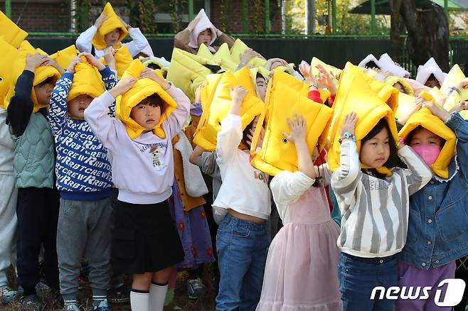 30일 대구 수성구 황금유치원에서 '2023년 재난대응 안전한국훈련'의 일환으로 열린 지진 대피 훈련에 참여한 어린이들이 지진경보가 울리자 지진방재모자로 머리를 보호하며 지도교사의 안내에 따라 신속히 대피하고 있다. 2023.10.30/뉴스1 ⓒ News1 공정식 기자