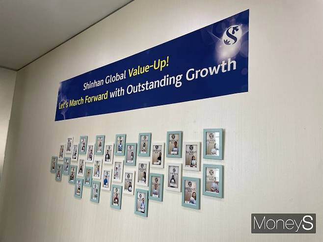 신한은행 싱가포르 지점에 직원들의 사진이 전시됐다. 벽면에는 '신한 글로벌 밸류업, 뛰어난 성장으로 전진'이라는 슬로건이 붙어있다./사진=이지운 기자