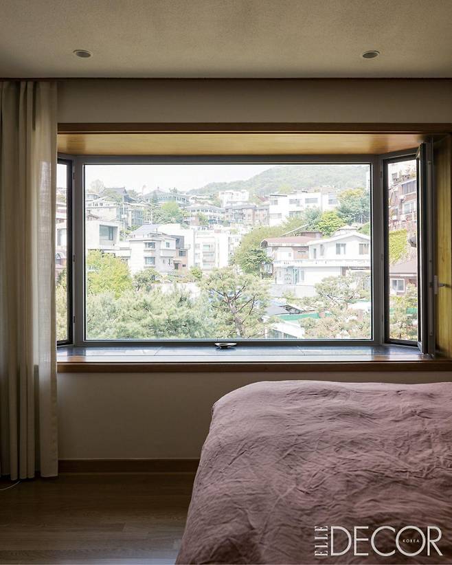 철마다 다른 풍경을 선사해주는 메인 침실의 넓은 창문. 리넨 베딩은 구다모에서 구입.