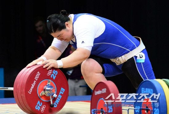 2012런던올림픽 여자 역도 75㎏이상급에 출전해 2회 연속 금메달에 도전한 장미란이 용상3차시기에 실패해 동메달 탈락이 확정된 후 무릎을 꿇고 바벨을 만지고 있다. /올림픽공동사진기자단