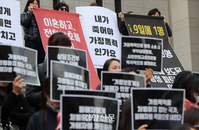 2018년 10월 29일 서울 종로구 세종문화회관 계단에서 열린 ‘국가의 가정폭력 대응 강력 규탄 시민사회 기자회견’에서 참가자들이 가정폭력 강력 대응을 촉구하는 손팻말을 들고 있다. 권도현 기자