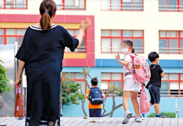 < 내 아이 괜찮을까… > 수도권을 중심으로 코로나19 확산세가 이어지는 가운데 18일 경기 수원의 한 초등학교 앞에서 학부모가 등교하는 딸을 배웅하고 있다. 이날 경기도는 도내 전 지역 거주자와 방문자를 대상으로 마스크 착용을 의무화하는 행정명령을 내렸다.   뉴스1