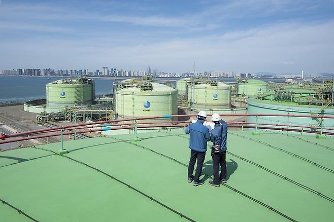 한국가스공사 직원들이 인천 연수구 인천 LNG 기지 저장 탱크 위에서 점검을 하고 있다. 바다 건너 송도국제도시가 보인다. 한국가스공사 제공