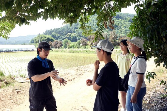김홍구(맨 왼쪽) 이사가 소중 학생기자단에게 토마토·수박 재배 과정과 수확 방법을 설명했다.