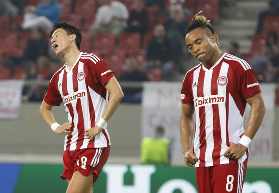 Olympiacos' Hwang Ui-jo, left, and Pierre Kunde react during a Europa League game against Nantes at Karaiskaki Stadium in Piraeus, Greece on Nov. 3, 2022. [REUTERS/YONHAP]