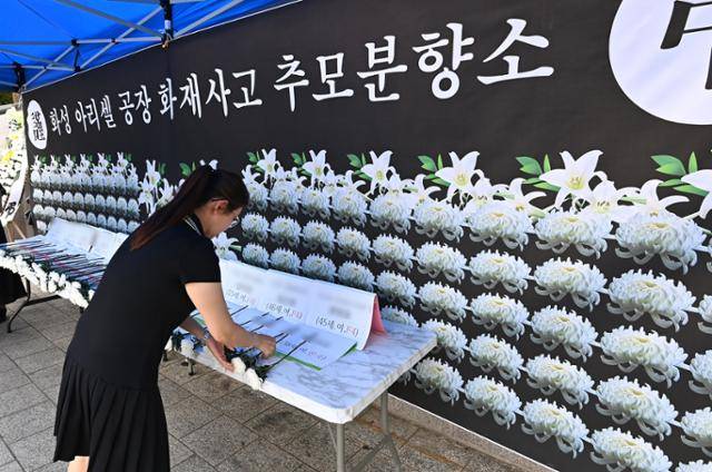 31명의 사상자가 발생한 경기 화성 리튬 배터리 공장 화재 참사 나흘째인 지난달 27일 경기 안산시 단원구 다문화 어울림 공원에 마련된 추모 분향소에서 추모객이 헌화하고 있다. 뉴시스