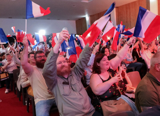 극우 정당 국민연합 지지자들이 30일 프랑스 총선에서 압승이 예상되자 프랑스 삼색기를 흔들며 환호하고 있다. AFP 연합뉴스