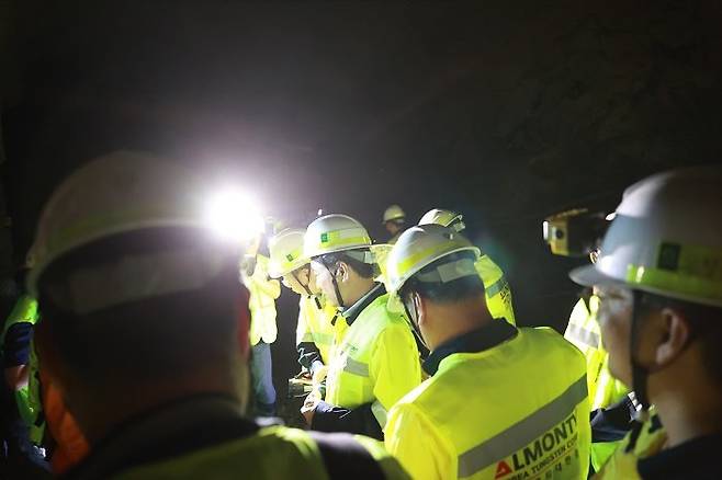 김진태 강원지사(가운데)가 상동광산 운반 갱도 안에서 알몬티 대한중석 관계자로부터 자외선 미네랄라이트로 비쳐진 텅스텐의 모습을 설명받고 있다.