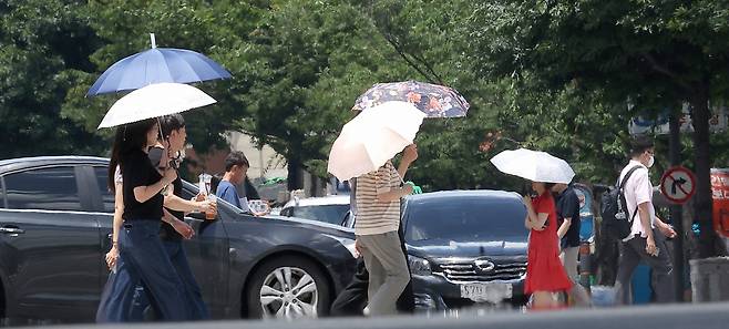 폭염주의보가 발효된 3일 시민들이 양산을 쓰고 이동하고 있다. 연합뉴스