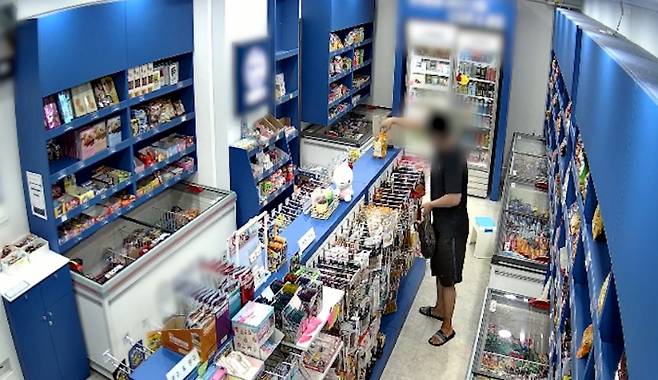 무인 아이스크림 매장에서 상습적으로 물건을 훔친 30대 남성이 업주에게 붙잡혔다. 남성이 검은봉지에 물건을 담고 있는 장면. CCTV 화면 캡쳐. 울산경찰청 제공